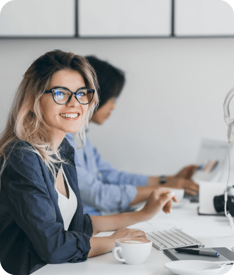 Ženy při pracovním stole s notebookem kávou a klávesnicí